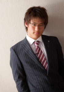 メガネを掛けたスーツを着た成人男性の半身