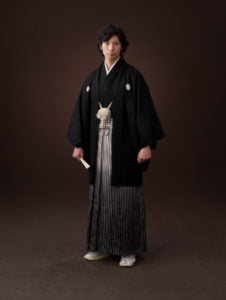 スクリーンの上で羽織袴を着た成人男性の立ち全身