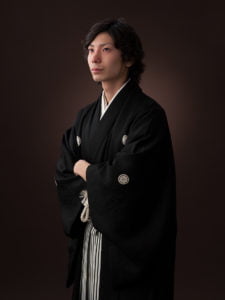 羽織袴を着た成人男性が腕組みをしている