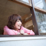 窓から外に微笑む女性