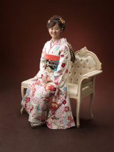 椅子に座った振袖を着た二十歳の全身