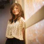 扉に寄り掛かる女性