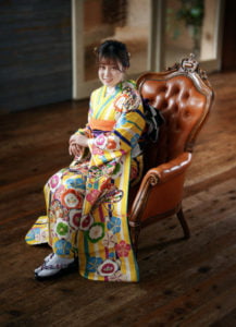 椅子に座った振袖を着た二十歳の全身