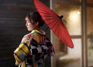 赤い傘を持って後ろ姿の振袖を着た二十歳