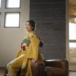 振袖を着た女性が斜め上を見て微笑んでいる