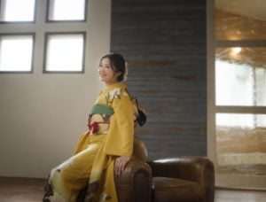 振袖を着た女性が斜め上を見て微笑んでいる