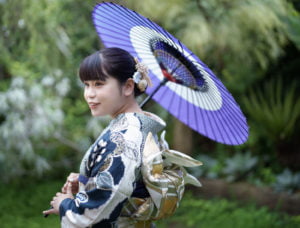 和傘を持った横向きの振袖を着た成人女性
