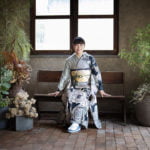 椅子に座って微笑む振袖を着た成人女性