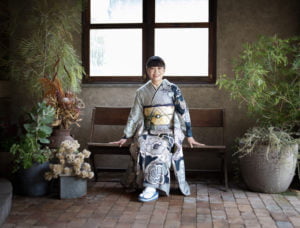 椅子に座って微笑む振袖を着た成人女性