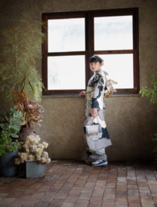 窓に手を掛け振り向く振袖を着た成人女性