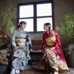 椅子に座って笑顔で話す振袖を着た2人
