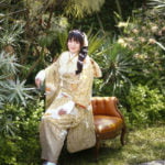 振袖を着て外で椅子に座った成人記念写真